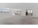 Expansive and well-lit open living space features neutral carpet and access to the kitchen at 6955 Elysian Valley Ave, Las Vegas, NV 89113