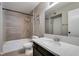 Bathroom featuring a shower-tub combo with grey tile and a vanity with light countertops at 698 S Racetrack Rd # 114, Henderson, NV 89015