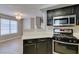 Open concept kitchen with an island, a stainless steel microwave, and a gas range at 698 S Racetrack Rd # 114, Henderson, NV 89015