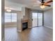 Bright living room features a fireplace, ceiling fan, and sliding glass doors leading to a balcony at 698 S Racetrack Rd # 114, Henderson, NV 89015