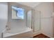 Bathroom showcasing a tub with a window view and a separate glass-enclosed shower at 7035 Chestnut Valley St, Las Vegas, NV 89166
