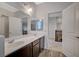 Bathroom featuring a dual sink vanity, a large mirror, and wood-look flooring at 7035 Chestnut Valley St, Las Vegas, NV 89166