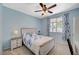 Bright bedroom with a window, bed with floral bedding, and a wardrobe with built in desk at 7035 Chestnut Valley St, Las Vegas, NV 89166