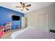 Bedroom featuring blue accent wall, ceiling fan, double closets and TV at 7035 Chestnut Valley St, Las Vegas, NV 89166