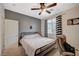 Bedroom features a ceiling fan, neutral carpet, and gray accent wall with black and white curtains at 7035 Chestnut Valley St, Las Vegas, NV 89166