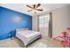 Bright bedroom featuring a ceiling fan, plush carpet, and a large window for natural light at 7035 Chestnut Valley St, Las Vegas, NV 89166