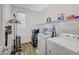 Well-equipped laundry room with washer, dryer, shelves, and hanging rack at 7035 Chestnut Valley St, Las Vegas, NV 89166