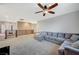 Spacious carpeted living room features a large sectional sofa, ceiling fan, and balcony access at 7035 Chestnut Valley St, Las Vegas, NV 89166