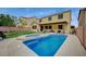 Backyard view of a sparkling private pool and spa, set against a well-maintained lawn and yellow home exterior at 7035 Chestnut Valley St, Las Vegas, NV 89166