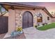 Grand stone entrance with arched double doors, beautiful stonework, and manicured landscaping at 728 N Kiel St, Henderson, NV 89015