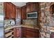 Elegant kitchen features rich wood cabinetry, granite countertops, and stainless steel microwave at 728 N Kiel St, Henderson, NV 89015
