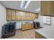 Spacious laundry room features modern machines, tile floor, and abundant cabinets at 728 N Kiel St, Henderson, NV 89015