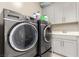 Well-equipped laundry room with a washer, dryer, sink, and cabinets at 731 Glowing Horizon St, Henderson, NV 89052