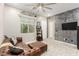 Comfortable living room with a leather couch, decorative wall, and modern ceiling fan at 731 Glowing Horizon St, Henderson, NV 89052