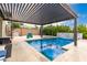 Luxurious pool area with covered pergola, waterfall feature, and built-in spa at 731 Glowing Horizon St, Henderson, NV 89052