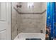 Bathroom with a tub and a shower head, as well as a blue bathmat and a blue shower curtain at 7401 Bridlehorne Ave, Las Vegas, NV 89131