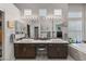 Bathroom featuring double sinks, granite countertops, modern cabinets, and natural light from windows at 7401 Bridlehorne Ave, Las Vegas, NV 89131
