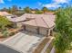 Tan home featuring a tile roof, three-car garage, and desert landscaping at 7401 Bridlehorne Ave, Las Vegas, NV 89131