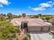 Beautiful single-story home with desert landscaping, tile roof, and an attached three-car garage on a sunny day at 7401 Bridlehorne Ave, Las Vegas, NV 89131