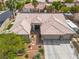 A bird's eye view of the front of the home with a three car garage and desert landscaping at 7401 Bridlehorne Ave, Las Vegas, NV 89131