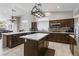 Modern kitchen with dark wood cabinets, a center island, stainless steel appliances, and tile backsplash at 7401 Bridlehorne Ave, Las Vegas, NV 89131