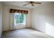 Neutral carpeted bedroom features ceiling fan and large window with neighborhood views at 7668 Broadwing Dr, North Las Vegas, NV 89084