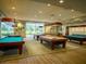 A billiards room with multiple well-lit pool tables for recreation at 7668 Broadwing Dr, North Las Vegas, NV 89084