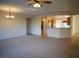 Spacious living room with adjacent kitchen and a combination of carpet and tile flooring at 7668 Broadwing Dr, North Las Vegas, NV 89084
