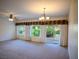 Open living room featuring neutral carpeting, a ceiling fan, and natural light at 7668 Broadwing Dr, North Las Vegas, NV 89084