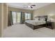 Spacious main bedroom featuring a ceiling fan, light neutral carpet, and a private balcony at 776 Flowing Meadow Dr, Henderson, NV 89014