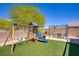 Backyard features a wooden playground, a dining set beneath a pergola, and low-maintenance artificial turf at 776 Flowing Meadow Dr, Henderson, NV 89014