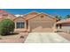 Home exterior featuring a two-car garage, desert landscaping, and a concrete driveway at 8028 Hurricane Cove Ct, Las Vegas, NV 89129