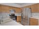 Updated kitchen boasts stainless steel refrigerator, gas range, ample cabinet space, and a breakfast bar at 8028 Hurricane Cove Ct, Las Vegas, NV 89129
