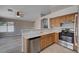 Well-lit kitchen featuring stainless steel appliances, oak cabinets, and a breakfast bar at 8028 Hurricane Cove Ct, Las Vegas, NV 89129