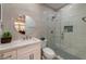 Modern bathroom featuring a glass-enclosed shower, a round mirror and white vanity at 8133 Desert Jewel Cir, Las Vegas, NV 89128