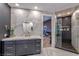 Modern bathroom with marble walls, a glass-enclosed shower, and a stylish vanity at 8133 Desert Jewel Cir, Las Vegas, NV 89128