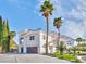 Elegant two-story house with a spacious driveway, palm trees, and meticulous landscaping at 8133 Desert Jewel Cir, Las Vegas, NV 89128