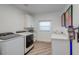 Bright laundry room with modern washer and dryer, white cabinets and quartz countertops, plus decor at 8133 Desert Jewel Cir, Las Vegas, NV 89128