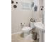 Elegant powder room with pedestal sink, decorative wall art, and tiled flooring at 8316 Gold River Ct, Las Vegas, NV 89113
