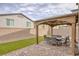 Covered outdoor patio with dining area, stone pavers, and artificial grass at 8316 Gold River Ct, Las Vegas, NV 89113