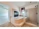 Luxurious bathroom featuring a jetted tub with fireplace and separate glass shower at 8431 Jeremiah Grove St, Las Vegas, NV 89123
