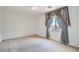 Bedroom with neutral walls, carpet, and a window with decorative curtains at 8431 Jeremiah Grove St, Las Vegas, NV 89123