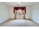 Carpeted bedroom with decorative window coverings and a large window overlooking a scenic view at 8431 Jeremiah Grove St, Las Vegas, NV 89123