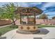 Outdoor backyard grilling and cooking space with custom stonework and metal sun shade at 8431 Jeremiah Grove St, Las Vegas, NV 89123