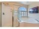Bathroom featuring a glass enclosed shower and separate soaking tub with glass block window at 890 Socorro Song Ln, Henderson, NV 89052