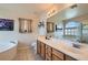 Bright bathroom with a double vanity, large mirror, and separate tub and shower at 890 Socorro Song Ln, Henderson, NV 89052