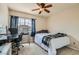 Well-lit bedroom with a ceiling fan, large window with neighborhood view, and a desk space at 890 Socorro Song Ln, Henderson, NV 89052