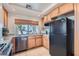 Bright kitchen with stainless steel appliances, a large window over the sink, and wood cabinets at 890 Socorro Song Ln, Henderson, NV 89052