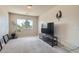 Cozy living room with a large window, neutral carpet, and a television set at 890 Socorro Song Ln, Henderson, NV 89052