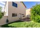 Home backyard with green artificial turf, door entrance and trimmed bushes at 9476 Milkweed Canyon Ave, Las Vegas, NV 89166